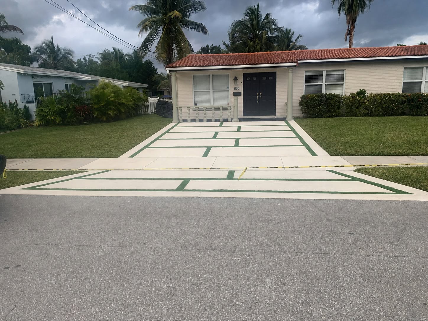 Completed Hollywood driveway with concrete squares, a border, and artificial turf channels.